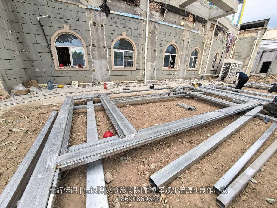 建筑楼下摆放着正在组装的户外金属标牌框架
