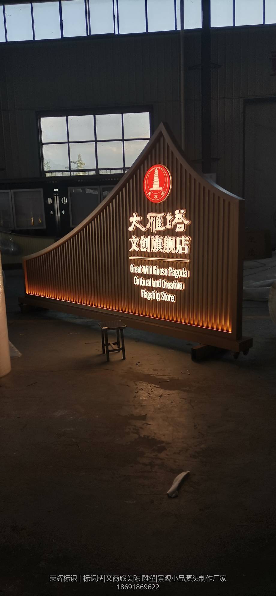 西安大雁塔文创旗舰店门头招牌成品，仿古屋檐造型配深色格栅面板与红色圆形徽标