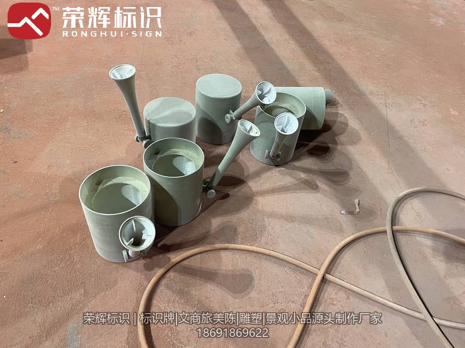 车间地面摆放的3D打印灯罩壳体,圆筒身配侧向喇叭出光口,内壁白色