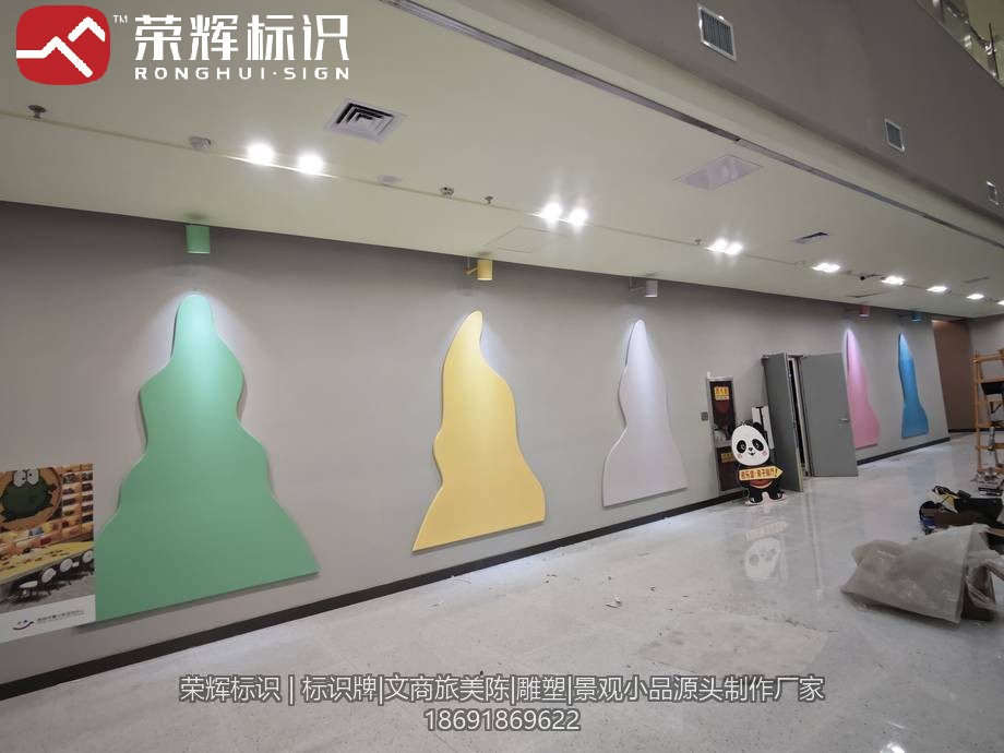 西安青少年宫走廊墙面安装完成的异形造型灯饰,多色圆角造型件错落排布