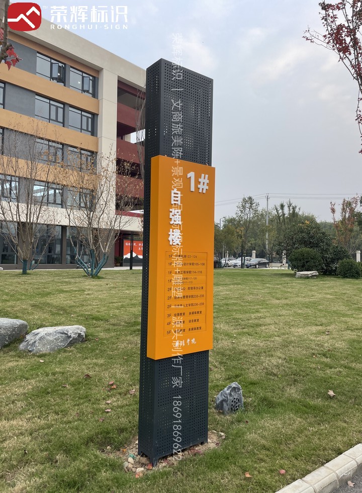 周至华清学院草坪上双柱式楼栋索引牌现场实景,黑色穿孔金属立柱配橙色面板标注楼层房间编号