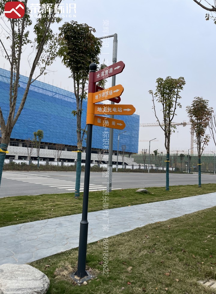 周至华清学院草坪立杆式多向指路牌现场实景,黑色金属立柱装多块分层色块箭头指示牌
