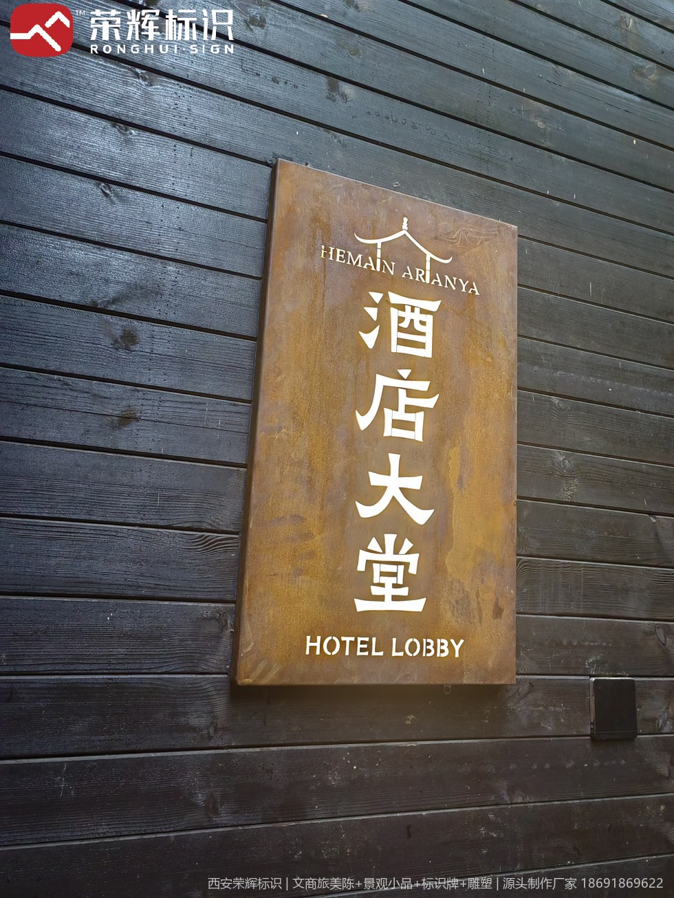 镇安合曼兰若度假酒店深色木饰面墙上的酒店大堂门牌,耐候钢板配白色中英文分级排版