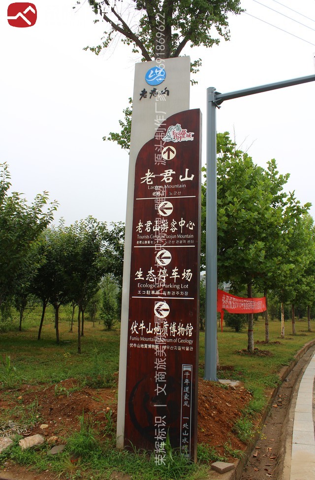 老君山景区入口广场全景导向牌现场实景,深褐色仿木纹面板分四组列出景区名与主要目的地并配中英韩三语
